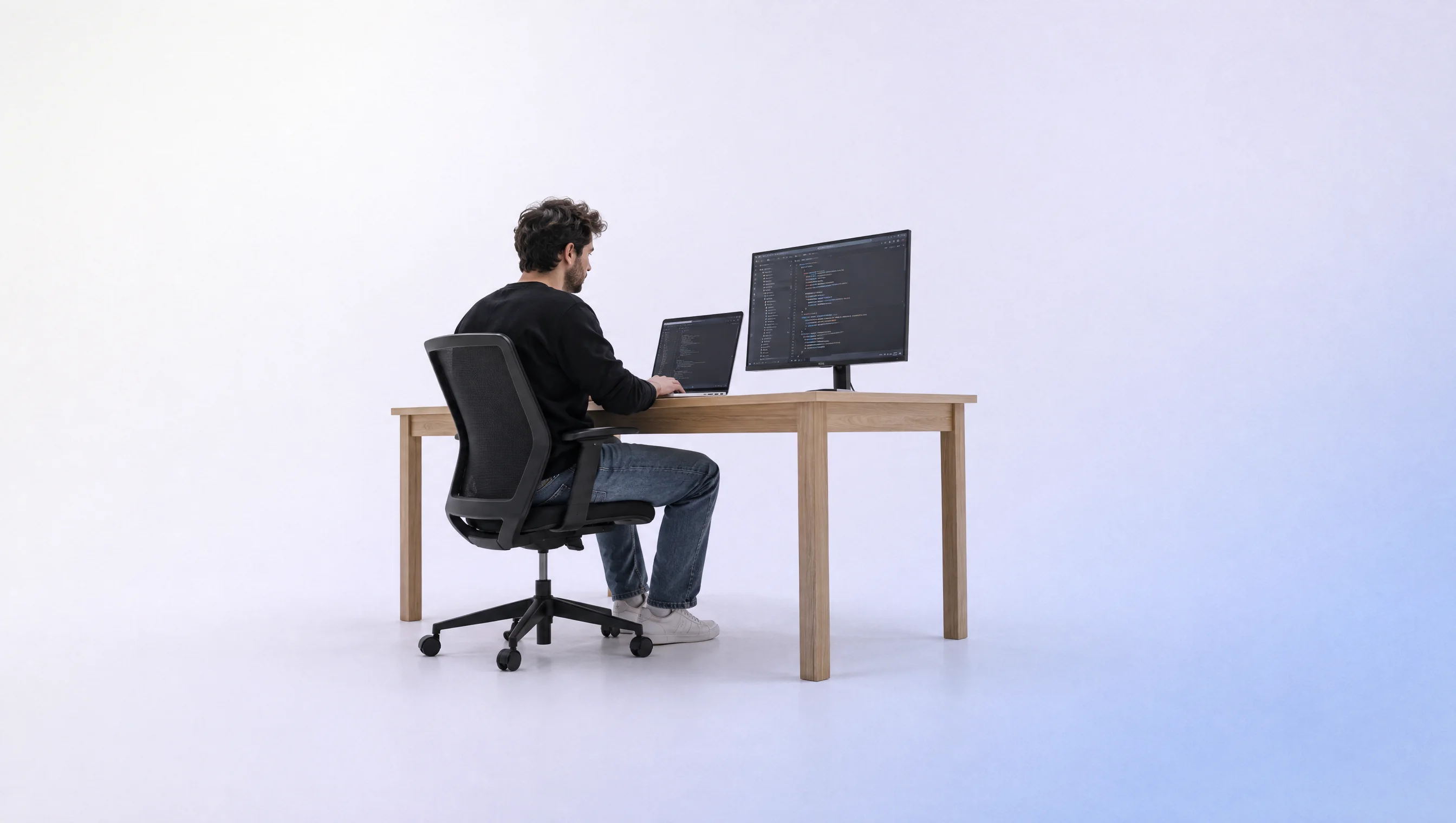 Engineer coding at a desk in an endless white room